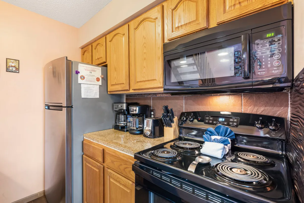 A modern kitchen scene highlights stainless steel appliances, granite countertops, and kitchen cabinets. The countertop is the focal point, suggesting culinary activity and inviting social interaction during meal prep.