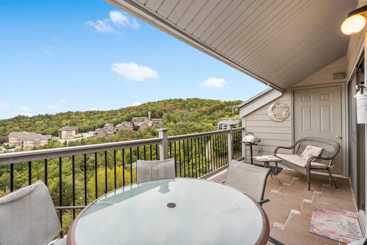 An outdoor dining table set on a deck with comfortable seating and a panoramic view of rolling hills. The setting is perfect for morning coffee, evening gatherings, or sunset cocktails overlooking nature.